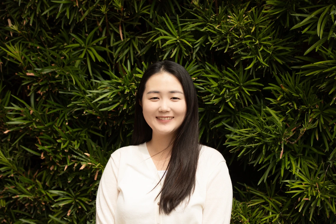 Chaelin Kwon Headshot against a background of slim-leafed green plants