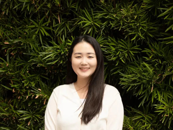 Chaelin Kwon Headshot against a background of slim-leafed green plants